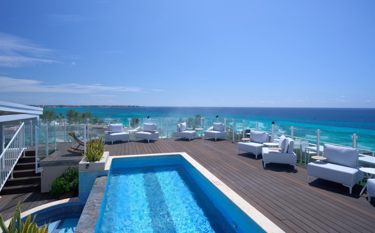 outdoor deck with pool and view of ocean