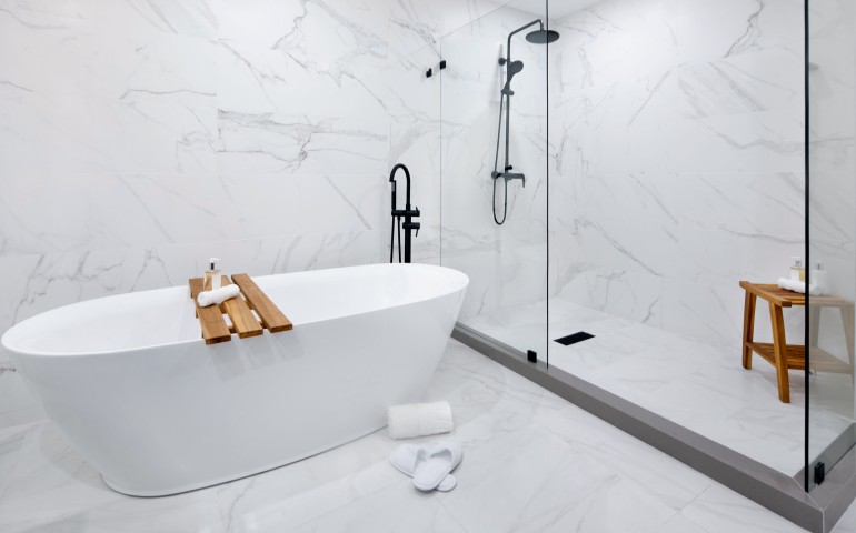marble bathroom with large white tub and shower