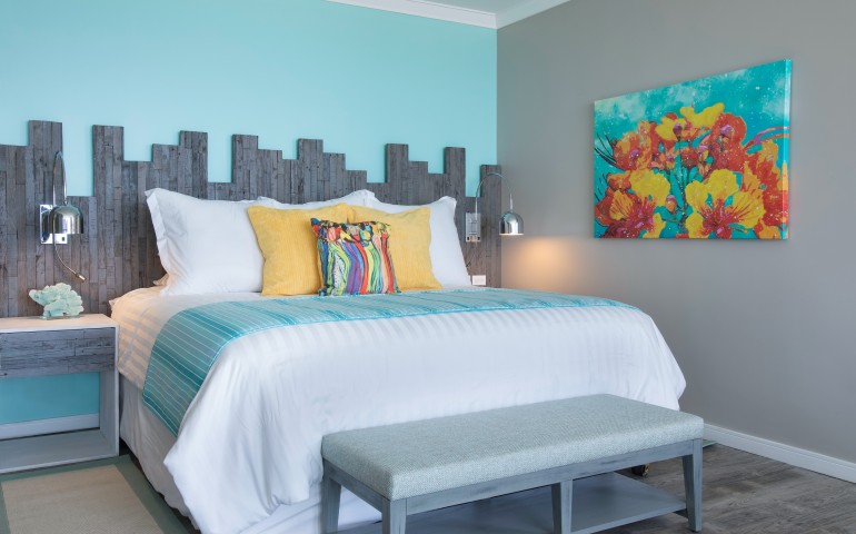 king bed with flower painting on the wall and wood texture behind bed