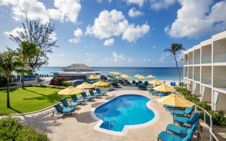 aerial shot of outdoor pool and yellow umbrellas