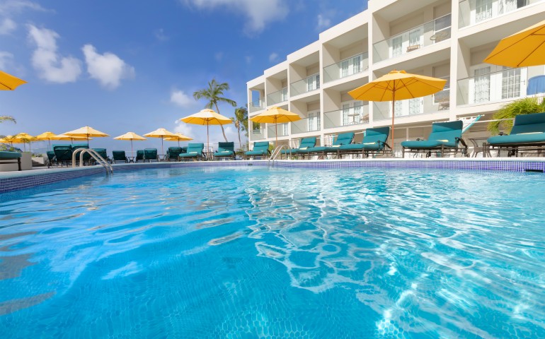 outdoor pool with lounge chairs and yellow umbrellas