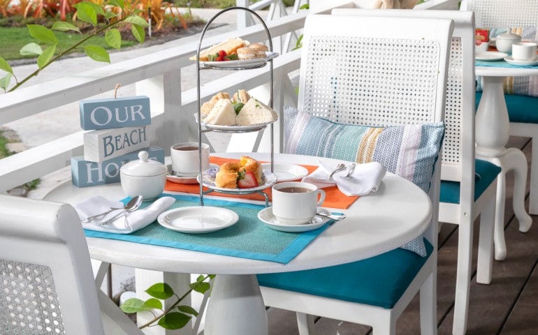 white dining table with stack of sandwich bites and fruit