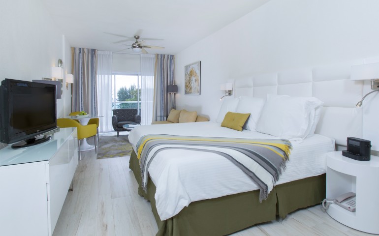 king bed with white sheets and colorful bed runner