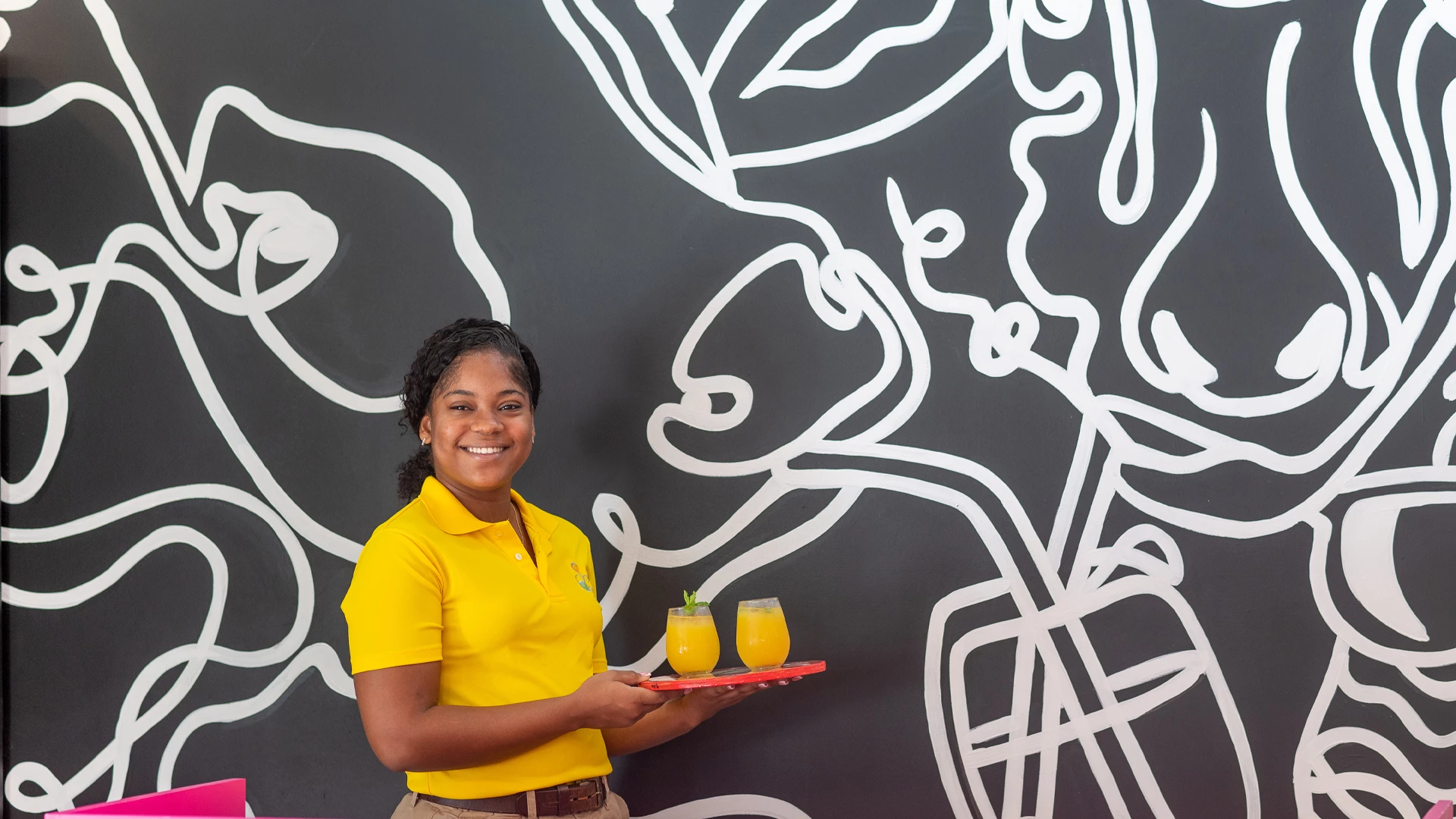 a woman holding a tray of drinks