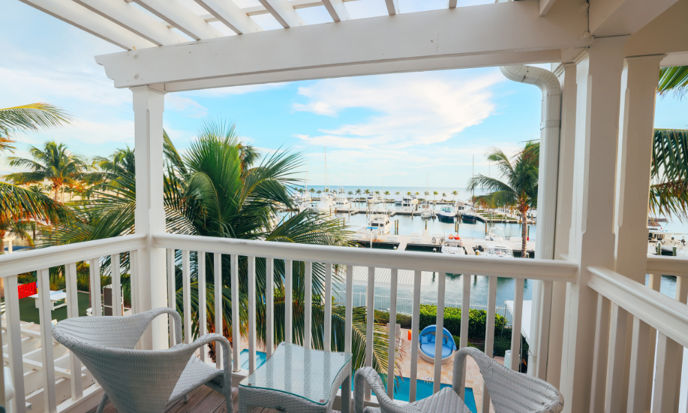 a deck with chairs and a view of the marina and boats