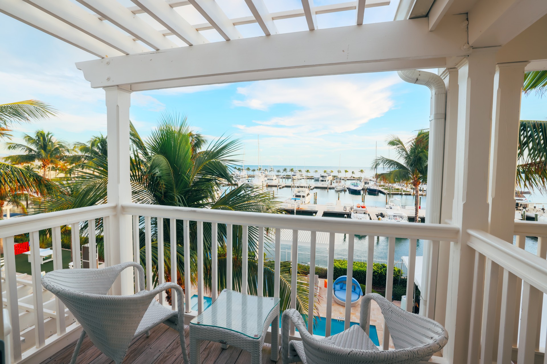 a deck with chairs and a view of the water and boats