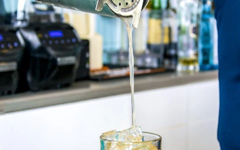a person pouring liquid into a glass