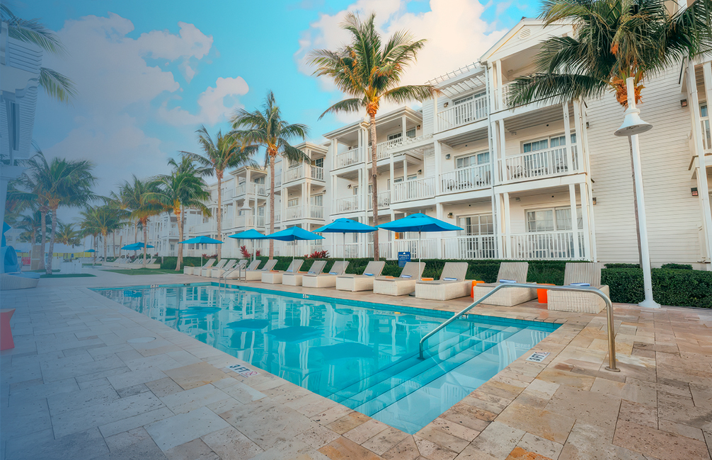 a pool with blue umbrellas and palm trees
