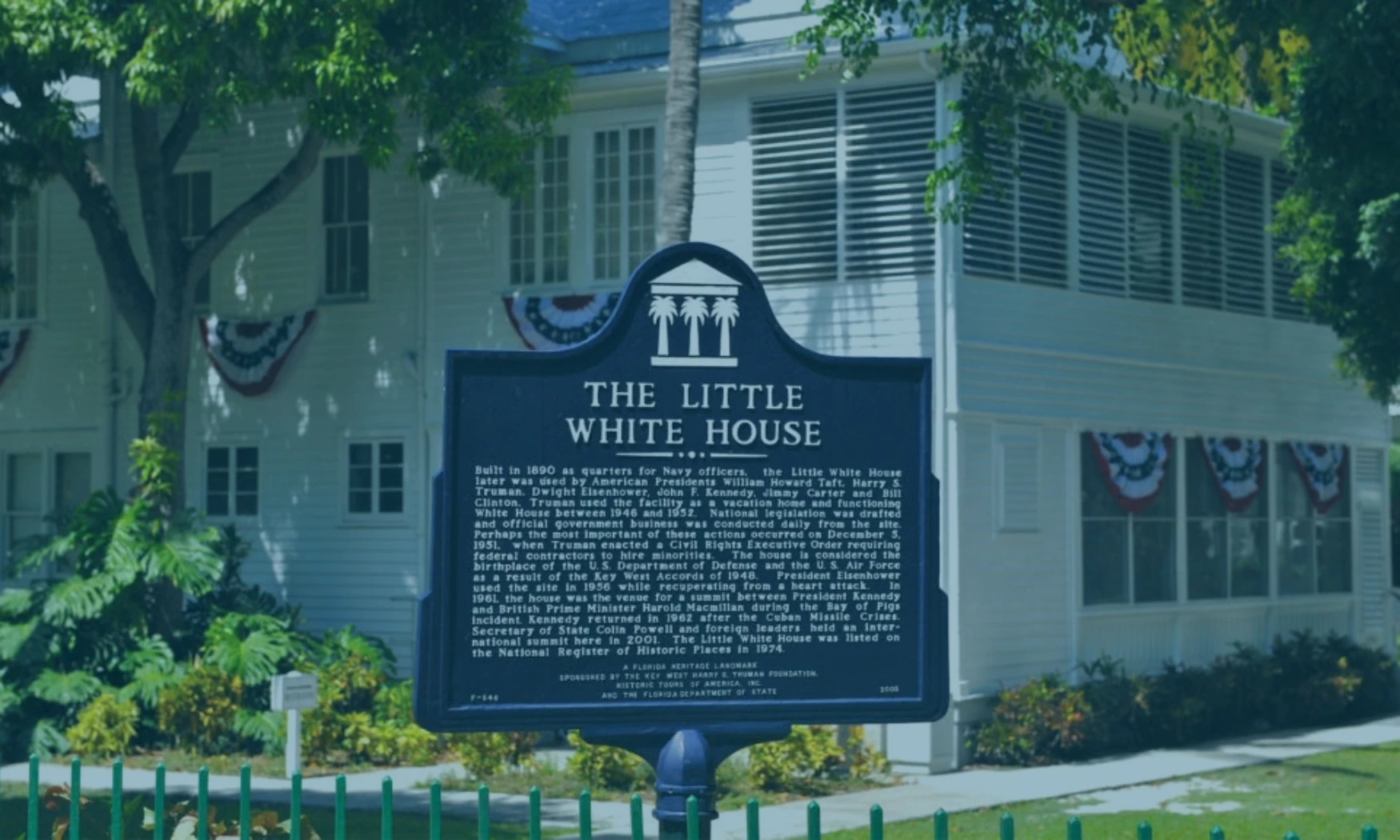 a sign in front of a white house