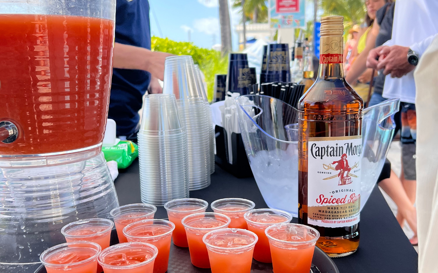 a table with cups and a bottle of liquor