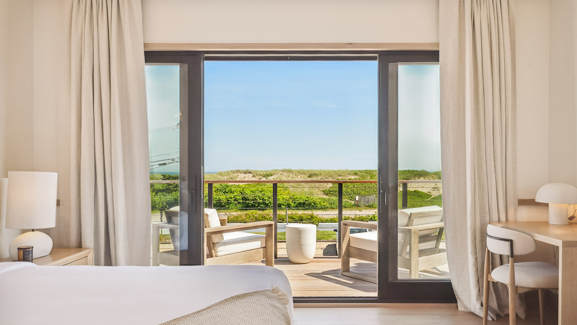 a bedroom with a deck and chairs outside