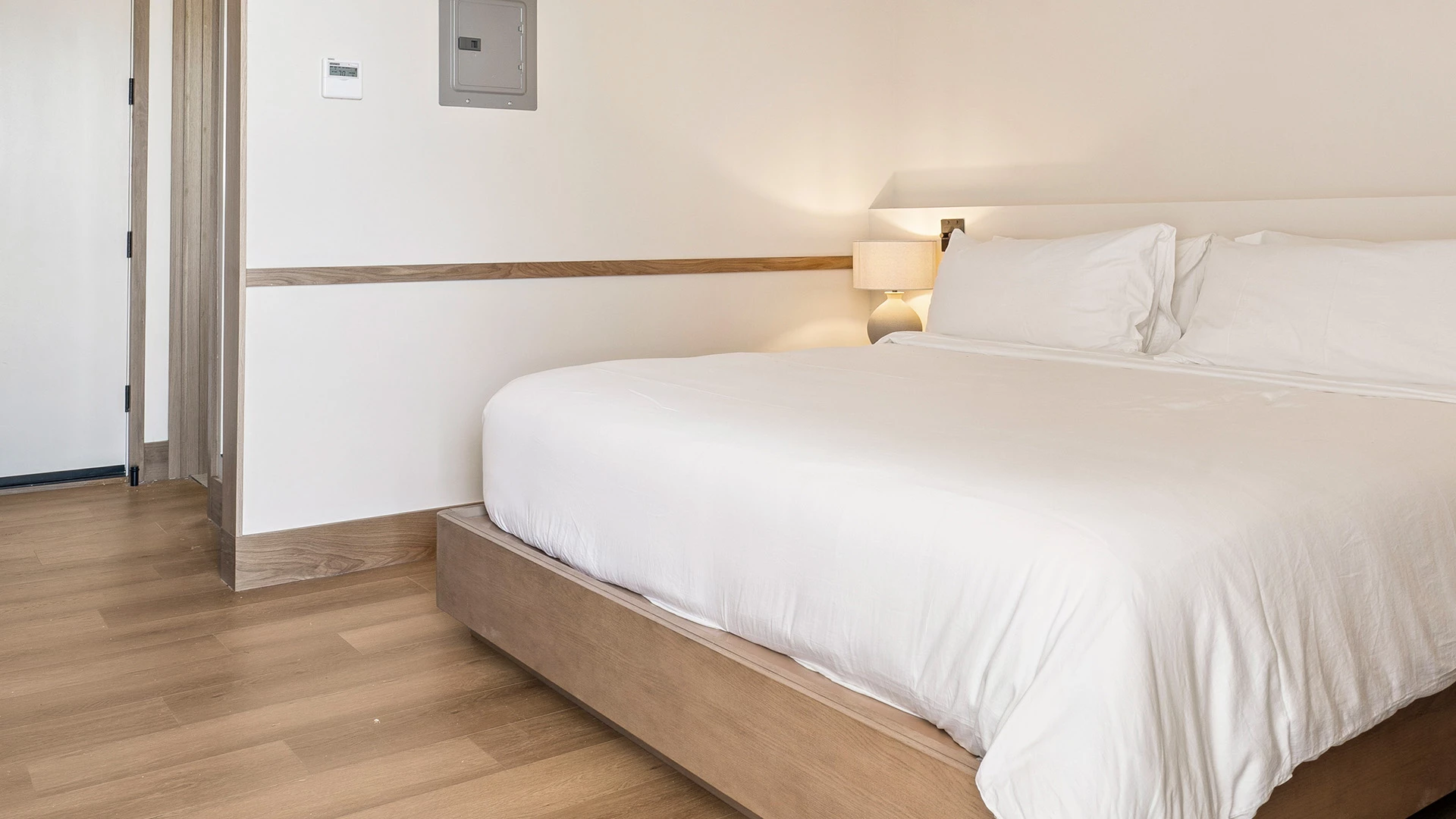 a bed with a wooden platform and lamps