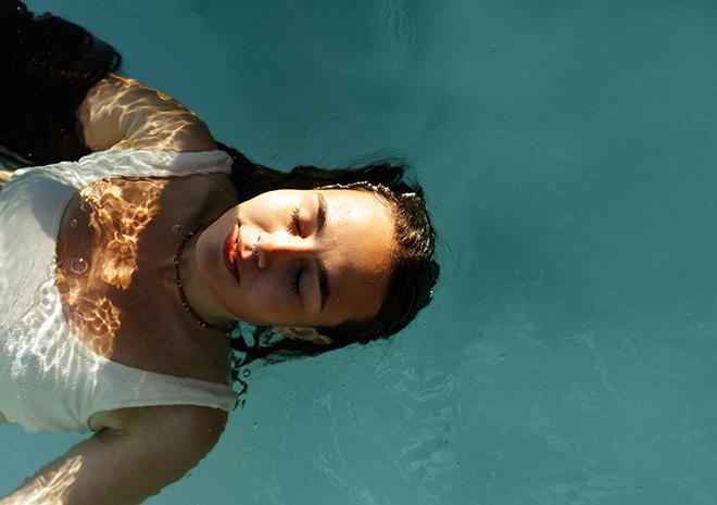 a woman in a pool with her eyes closed