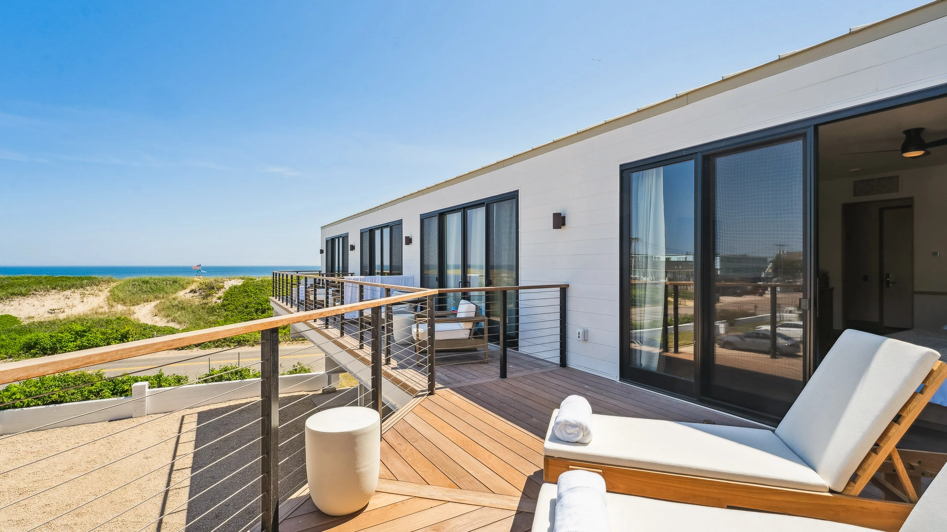 a deck with chairs and a railing on the side of it