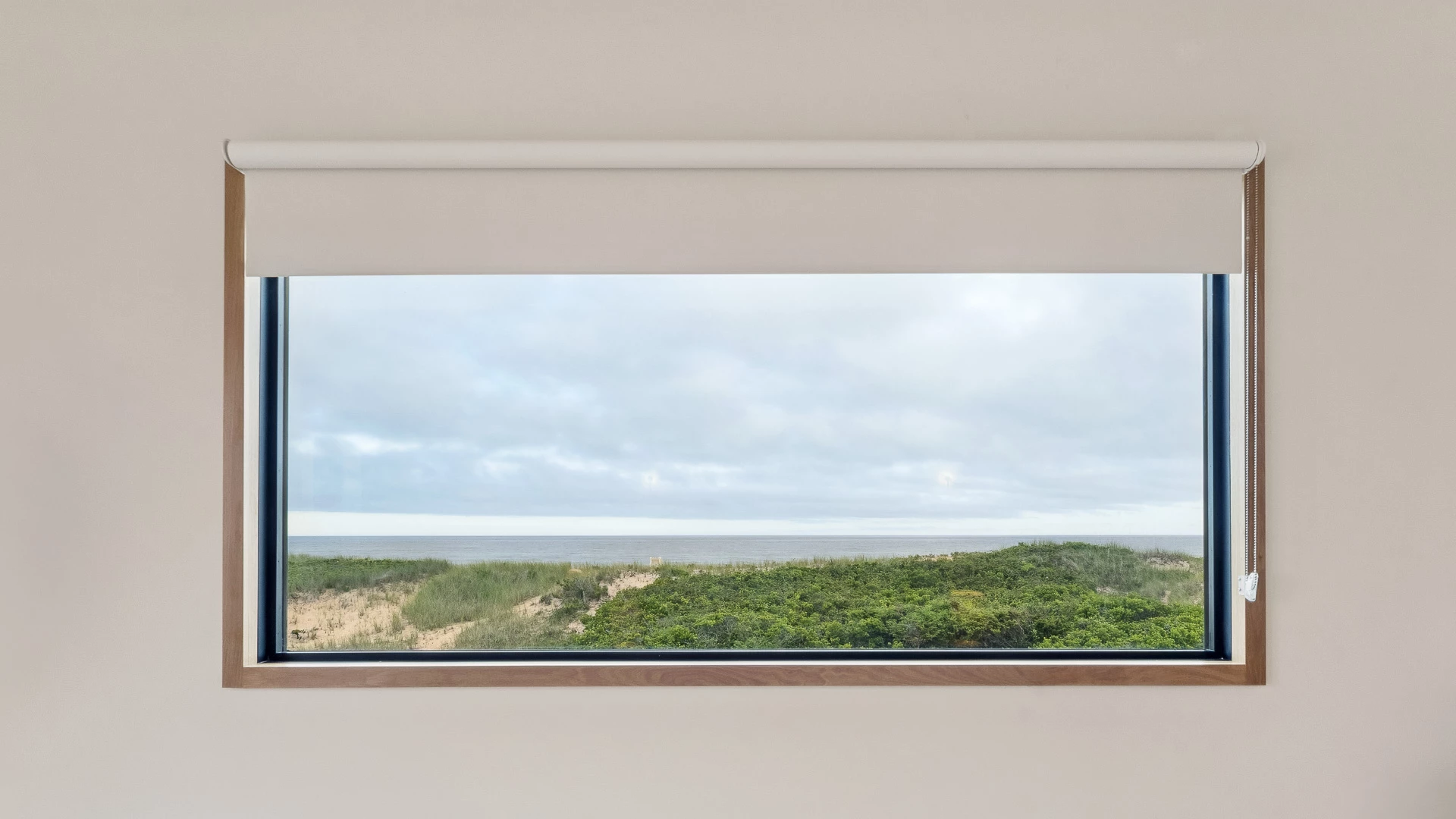 a window with a view of the ocean and sand