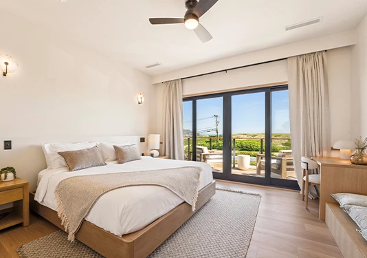 a bedroom with a large bed and a ceiling fan
