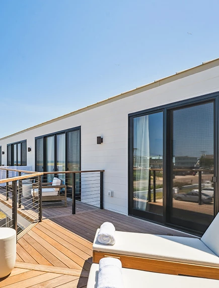 a white building with a deck and a white couch
