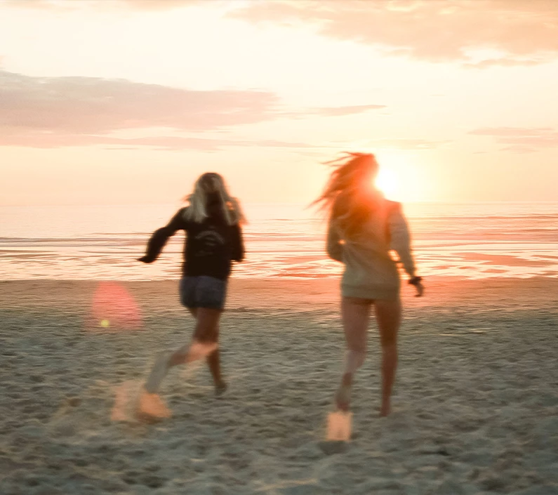 two women running on a beach