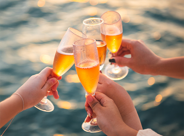 a group of hands holding up glasses of champagne