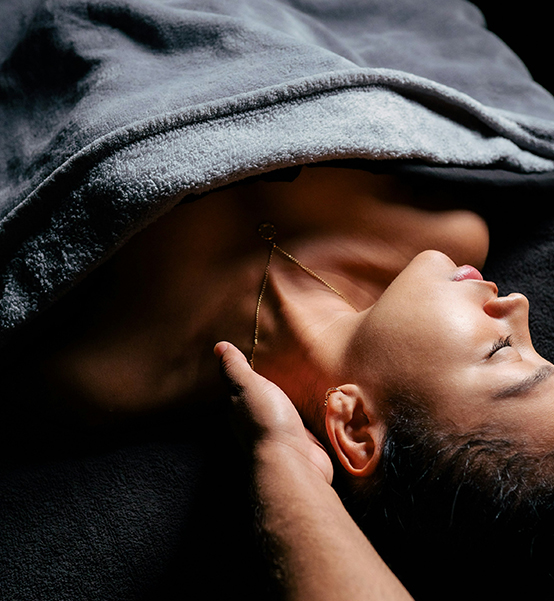a woman lying under a blanket