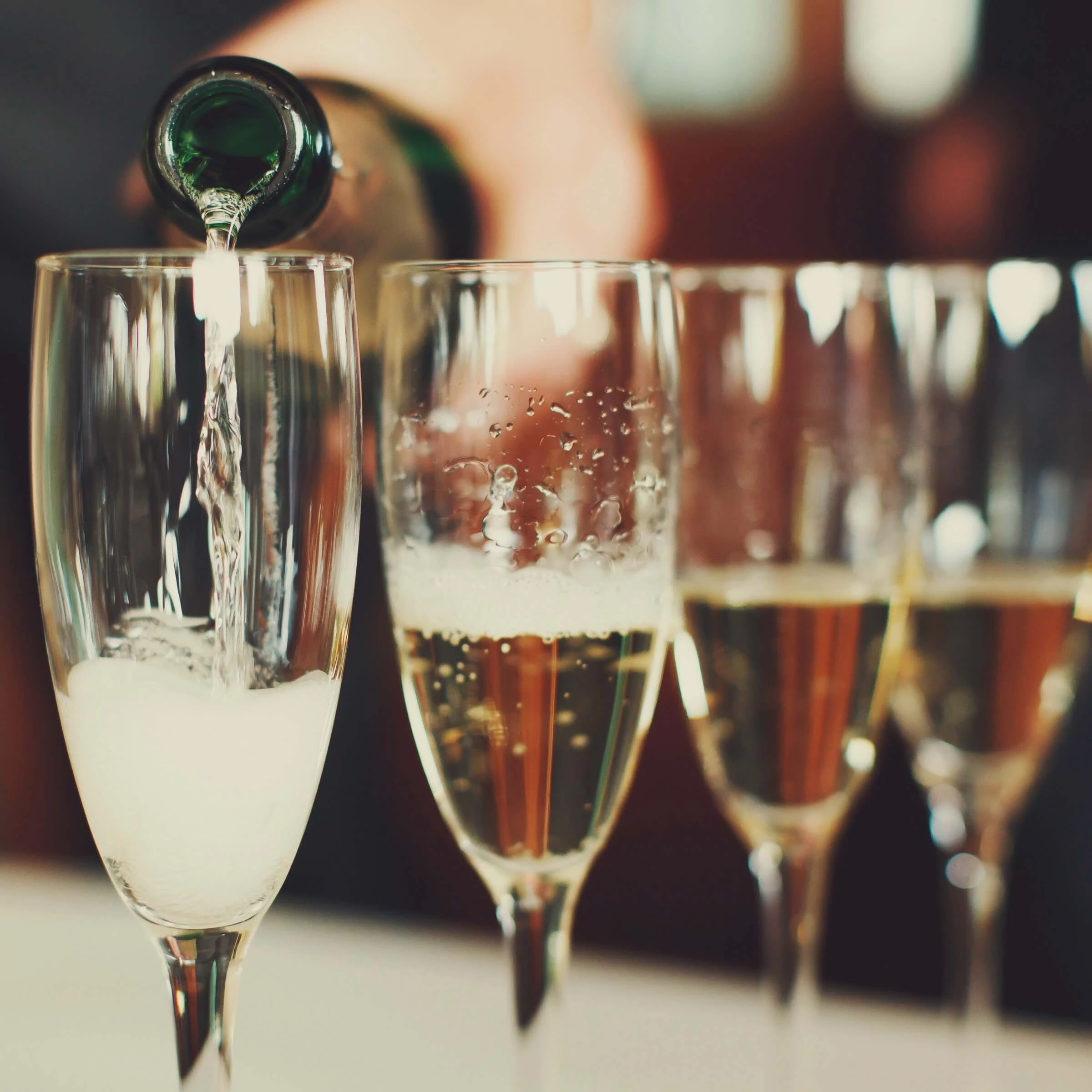 a person pouring champagne into a glass