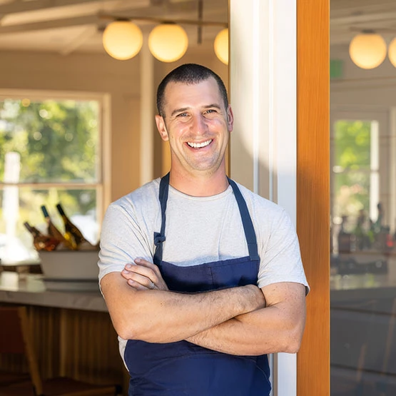 a man wearing an apron standing in front of a door