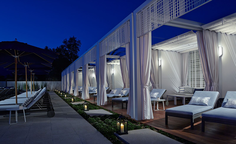 a patio with white curtains and a deck with a patio area