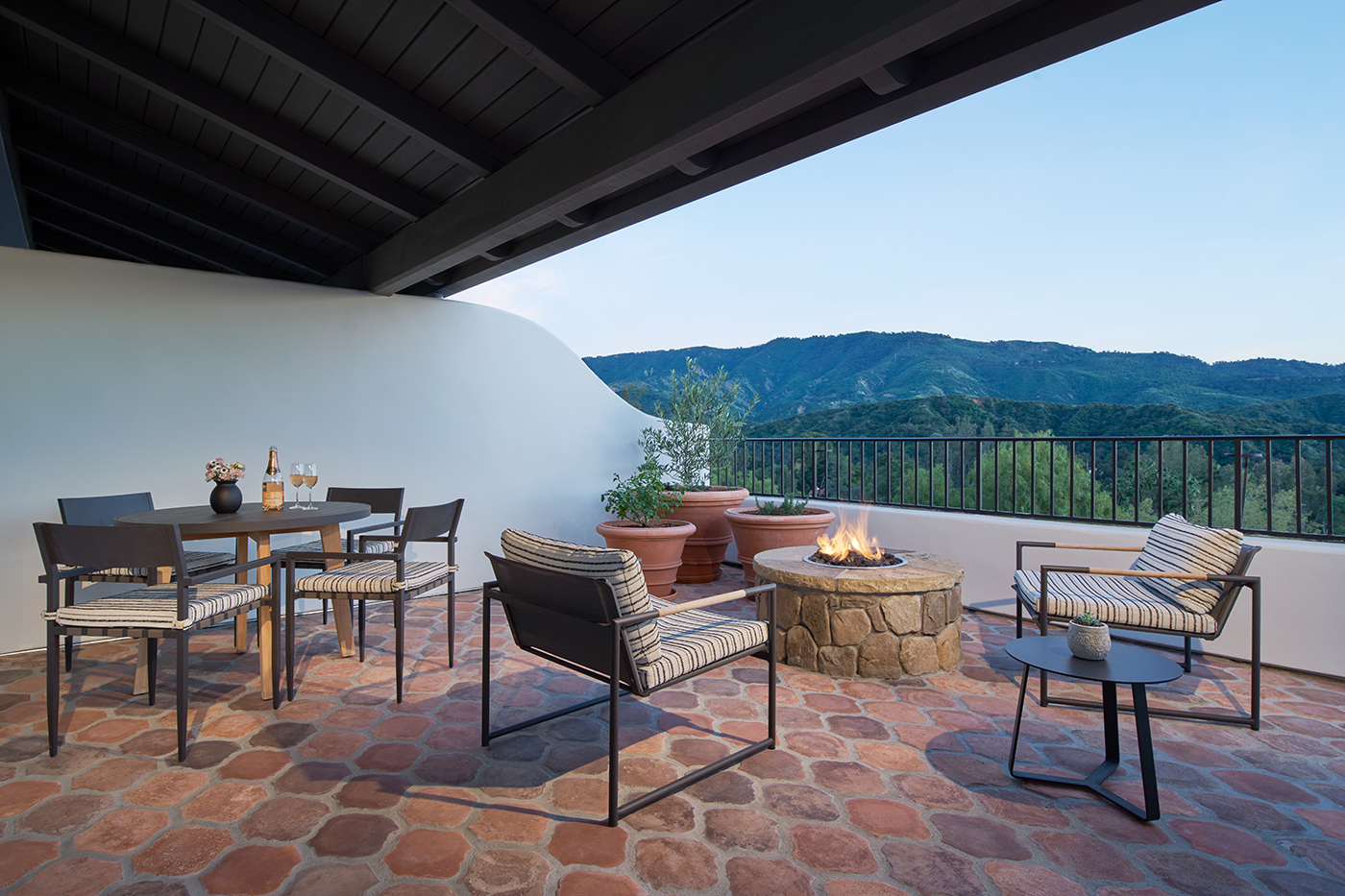 a patio with a fire pit and chairs