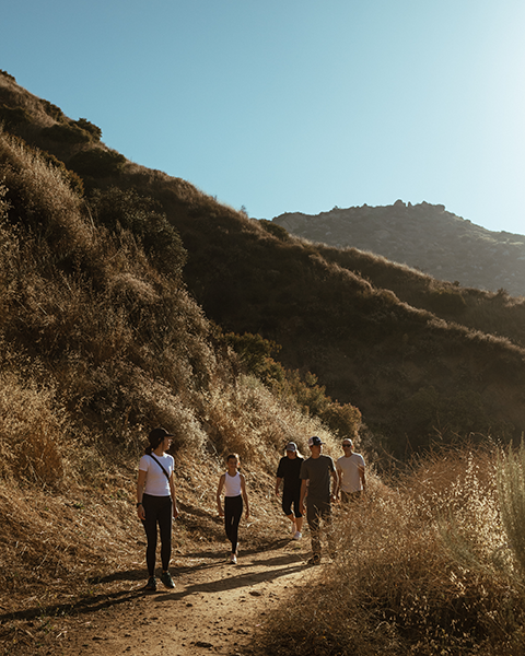 a group of people walking on a dirt path
