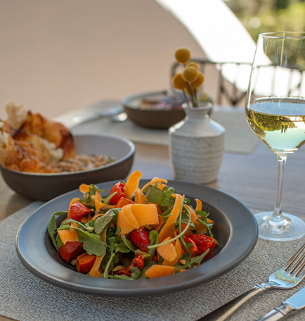 a plate of salad and a glass of wine