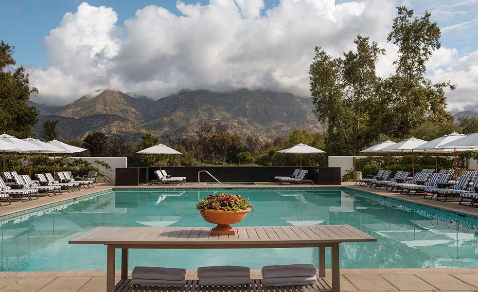 a pool with a bowl of flowers and umbrellas