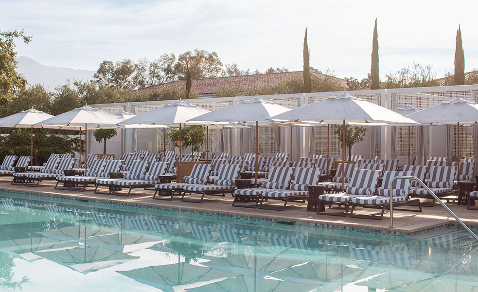 a pool with chairs and umbrellas