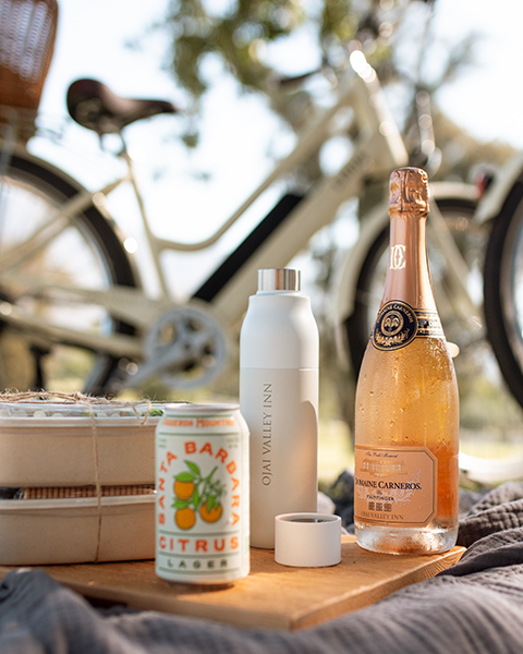 a bottle of champagne and a can of citrus juice