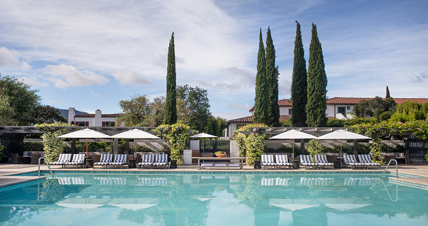 a pool with lounge chairs and umbrellas by it