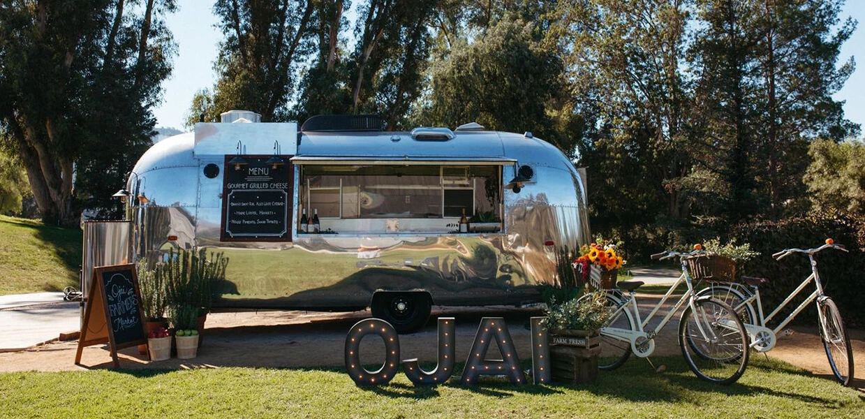 a silver trailer with flowers and a sign