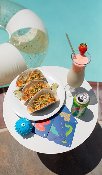 a plate of tacos and a drink on a table