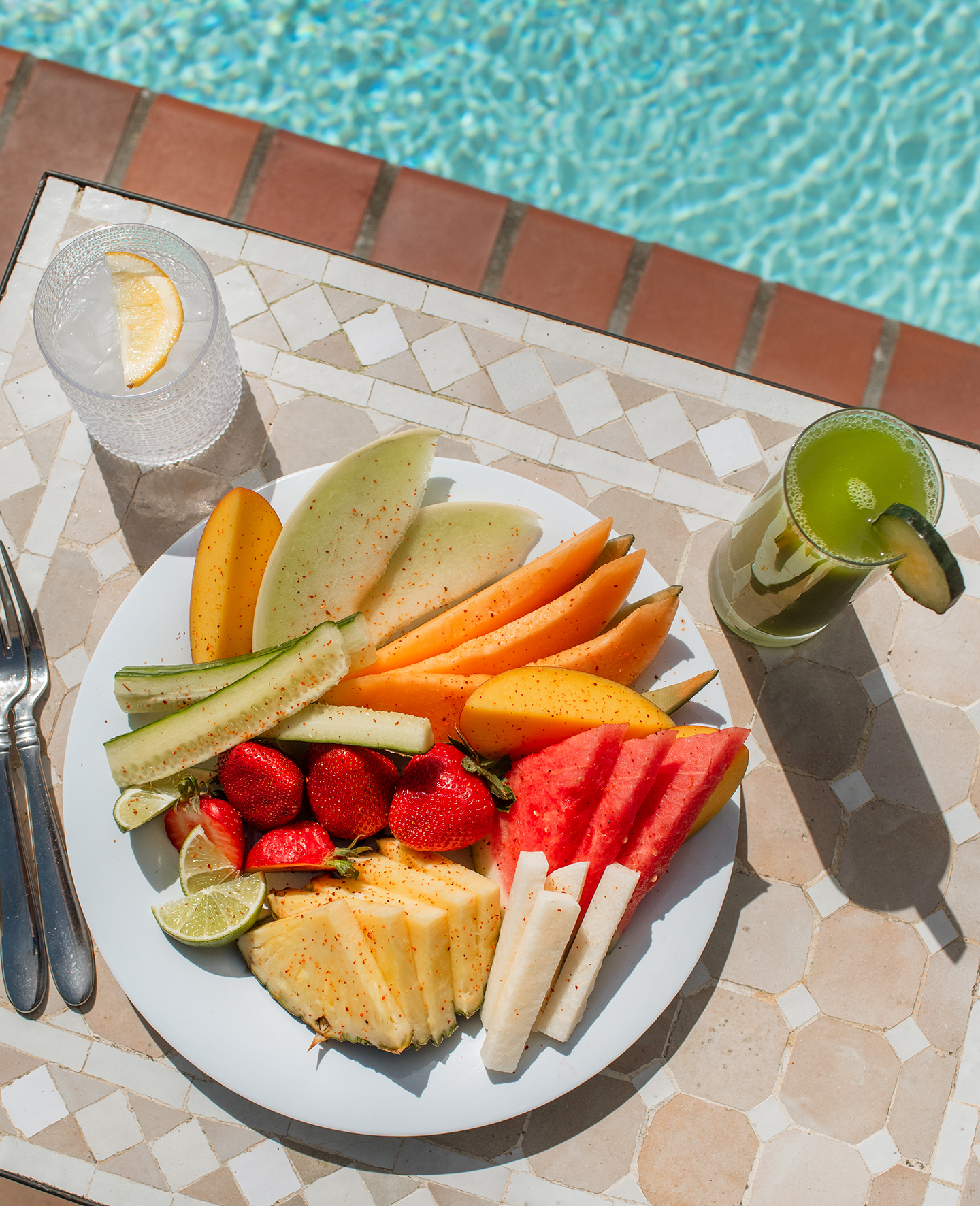 a plate of fruit and a drink on a table