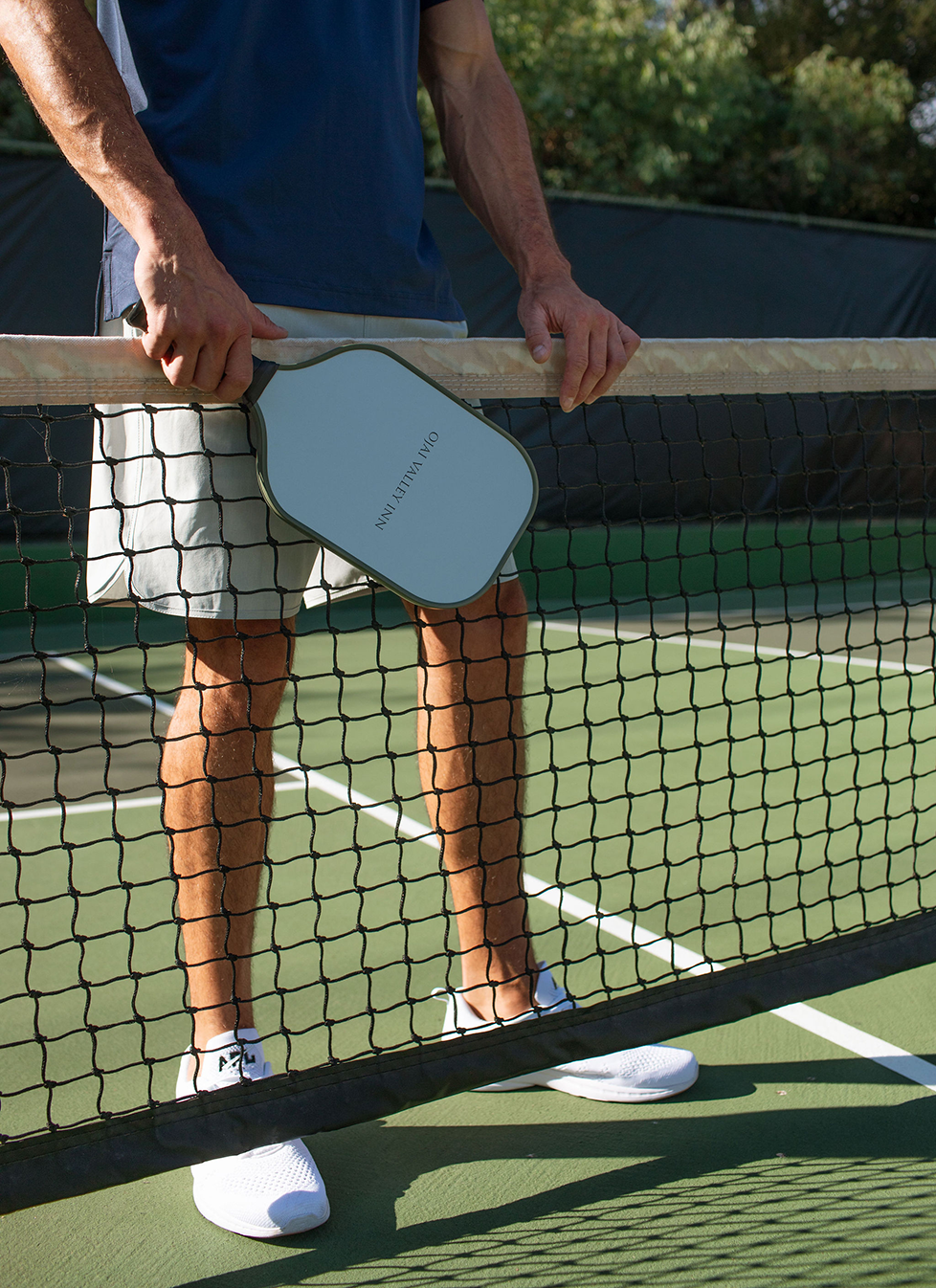 a man holding a paddle over a tennis net