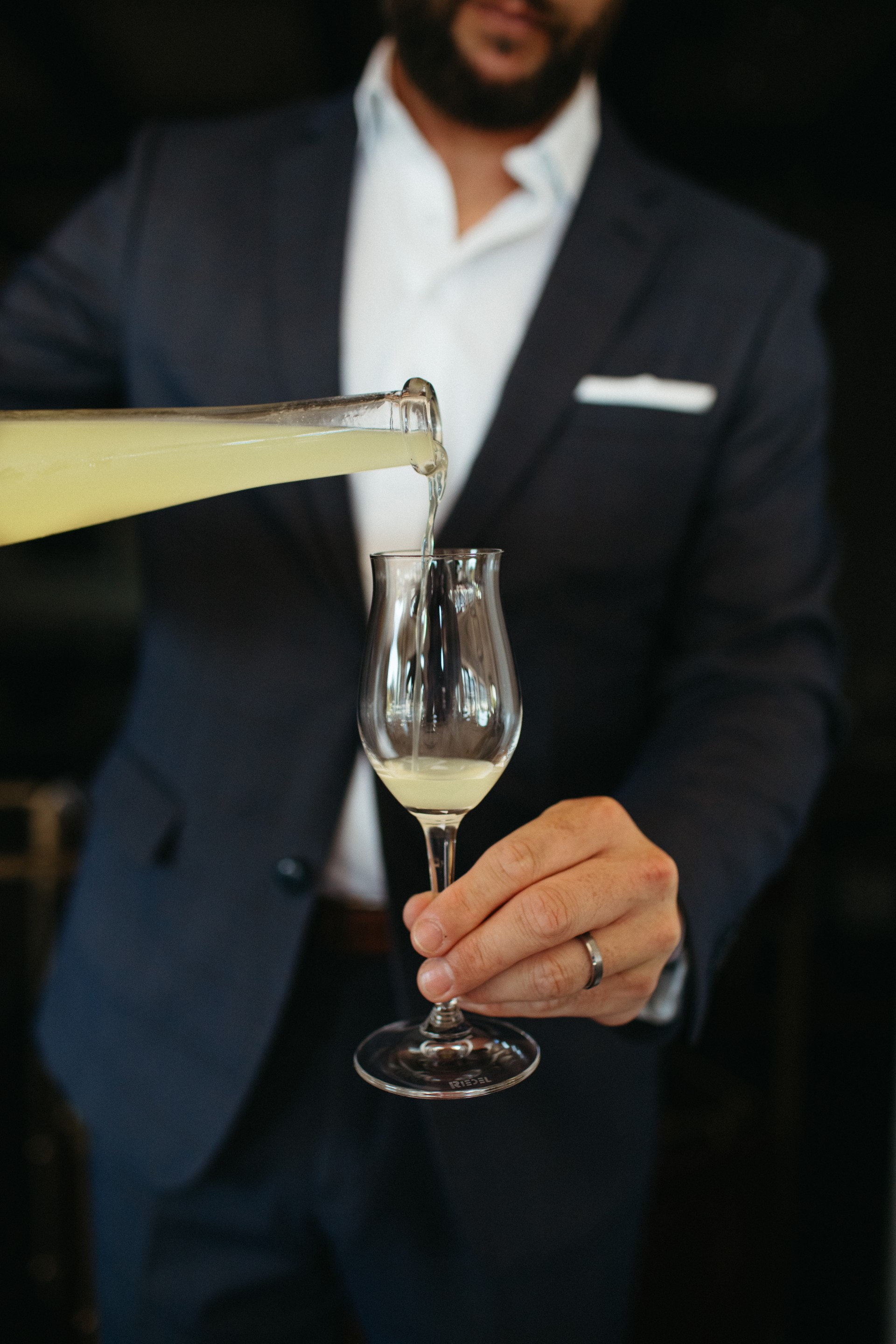 a person pouring liquid into a glass