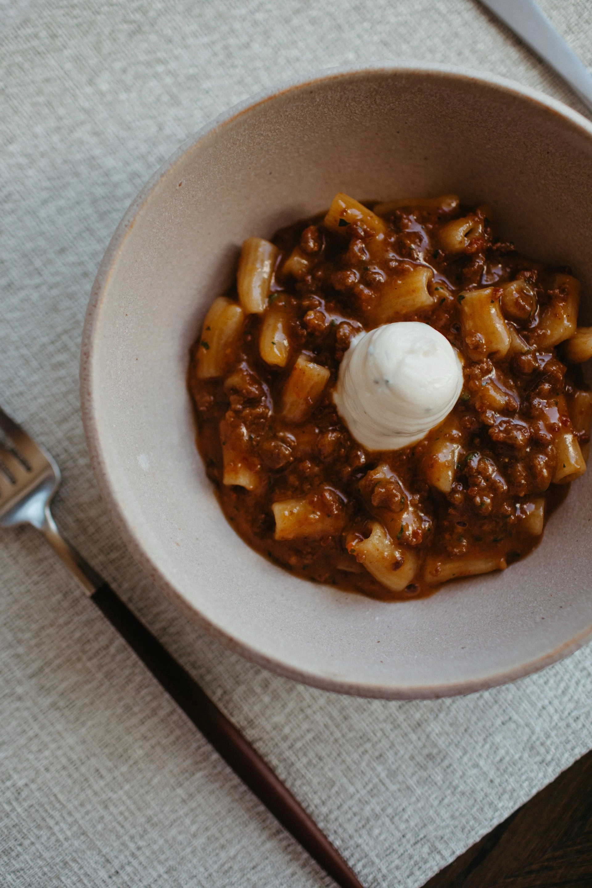a bowl of pasta with sauce and a fork