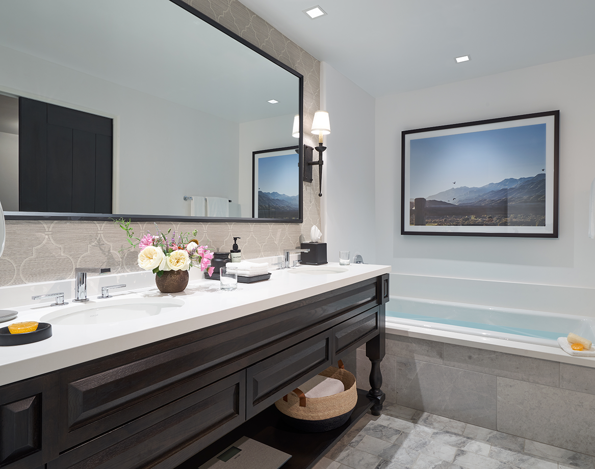 a bathroom with a large mirror and a tub