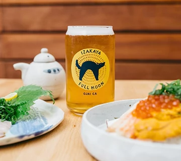 a can of beer next to a plate of food