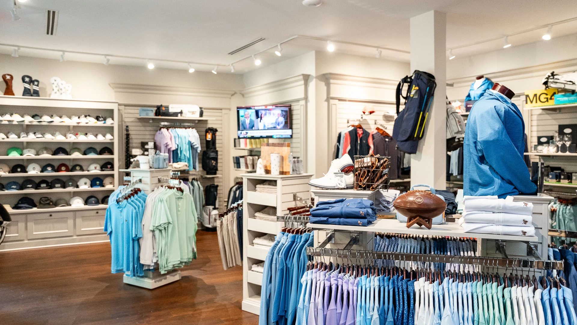 a store with clothes on swingers and a television