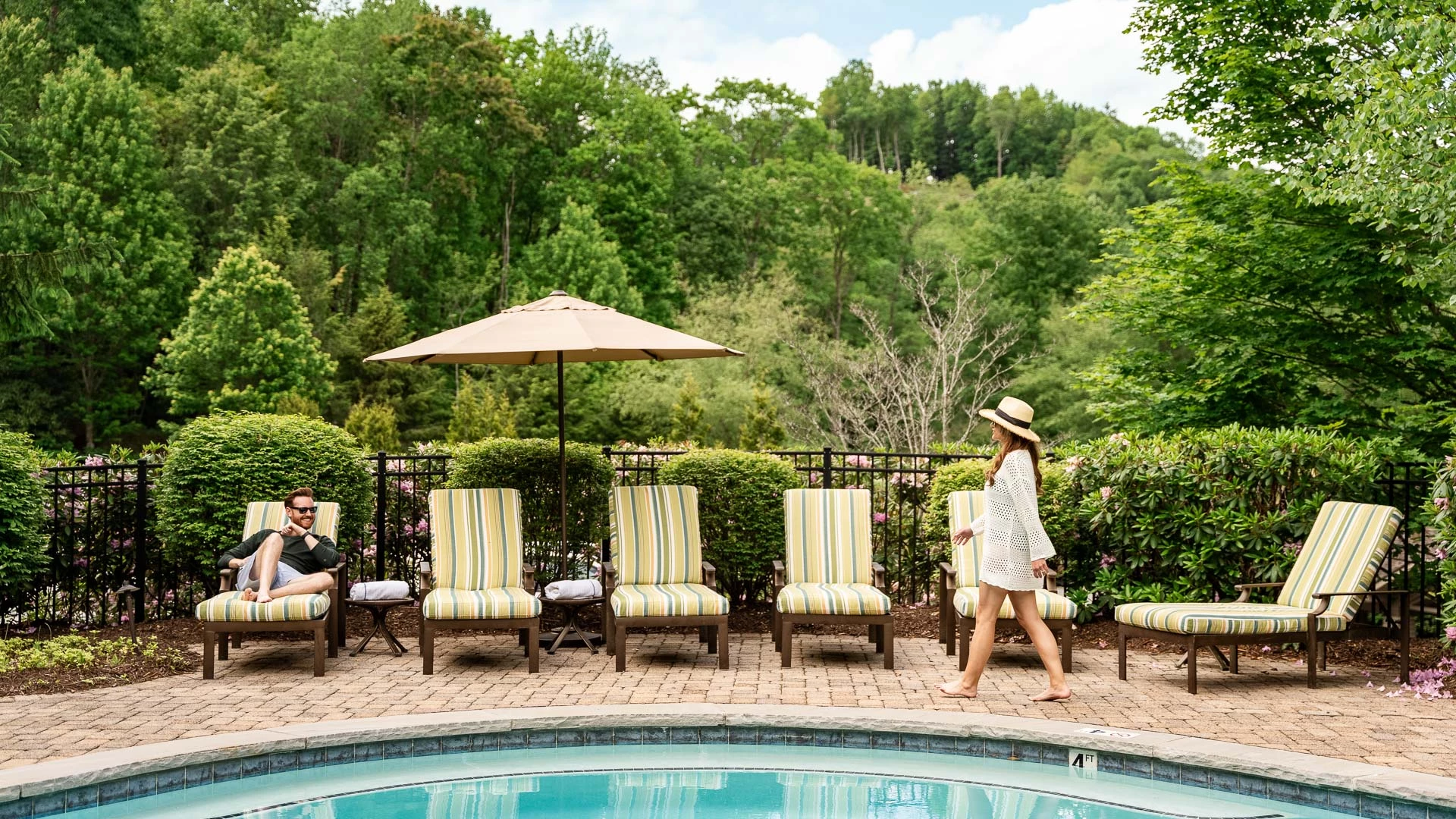 a group of people walking by a pool