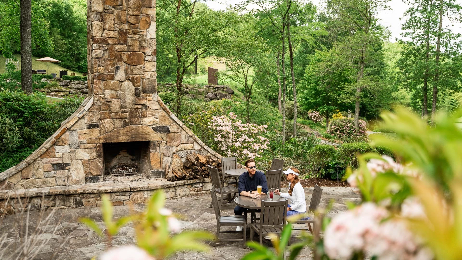 a man and woman sitting at a table outside