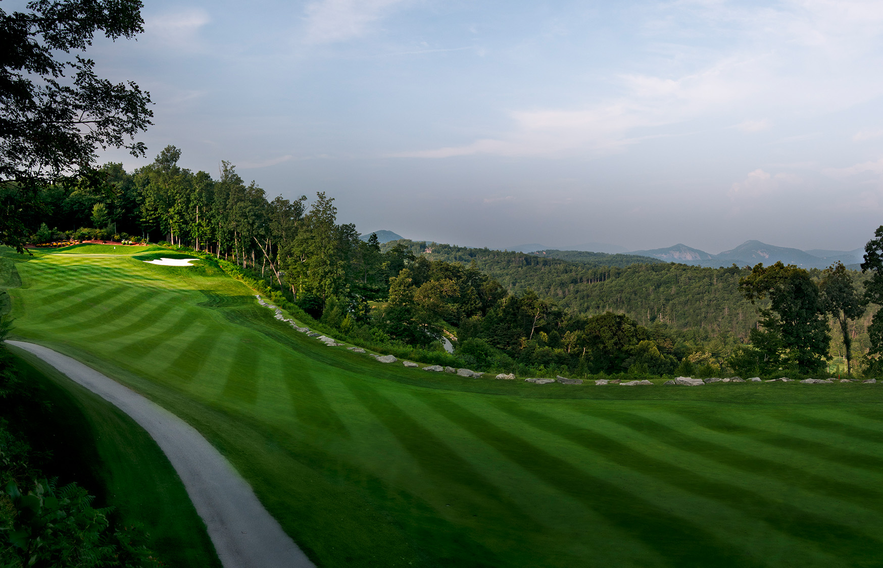 a golf course with trees and a path