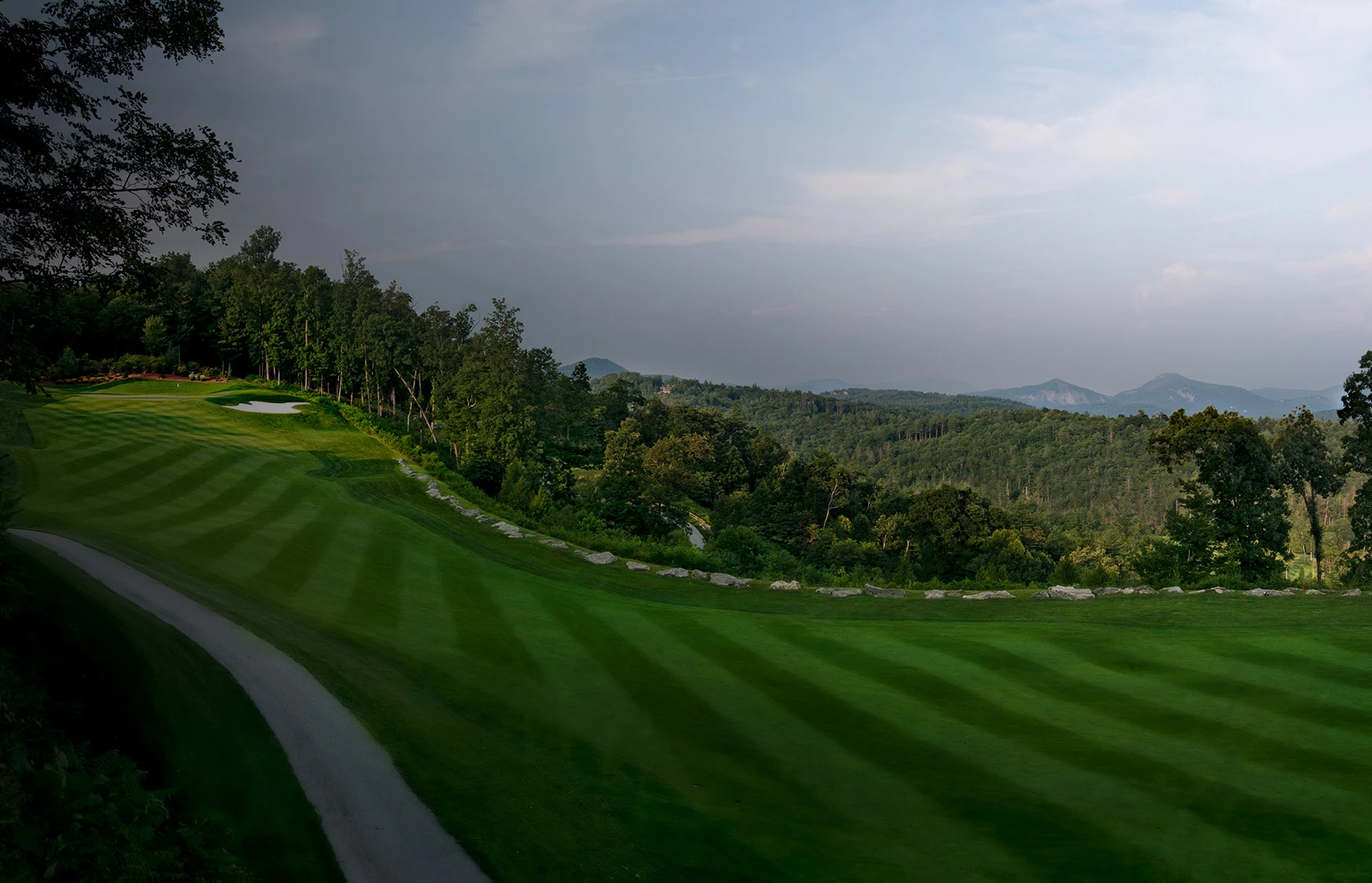 a golf course with trees and a path