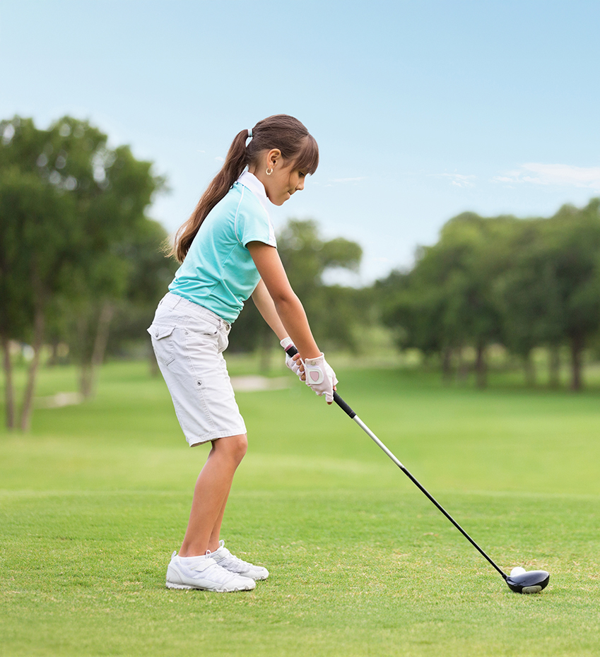 a girl playing golf on a golf course