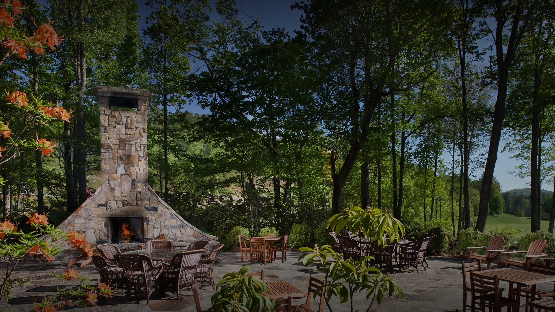 a patio with chairs and tables and a fireplace