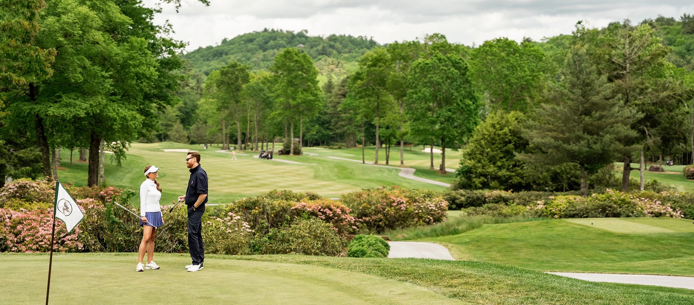 a two men standing on a golf course